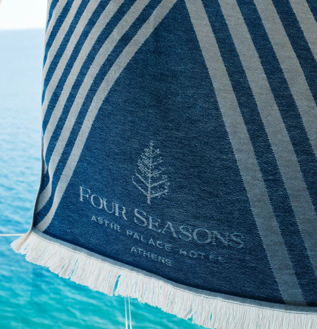 A luxury towel displayed as a welcome gift on a hotel bed, part of a curated hospitality set.